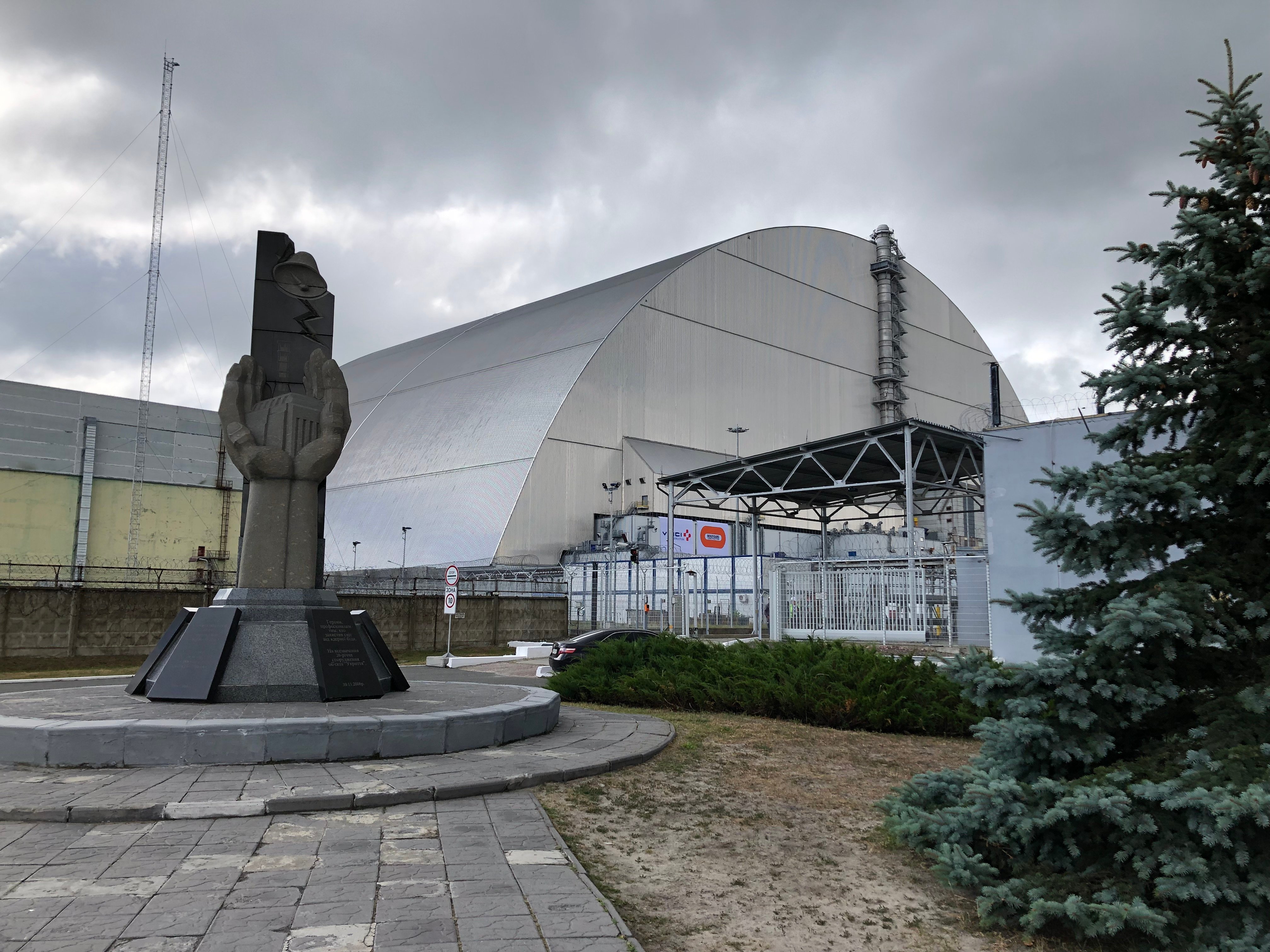 Kuppelformet stålkonstruksjon. Statue i forgrunnen.