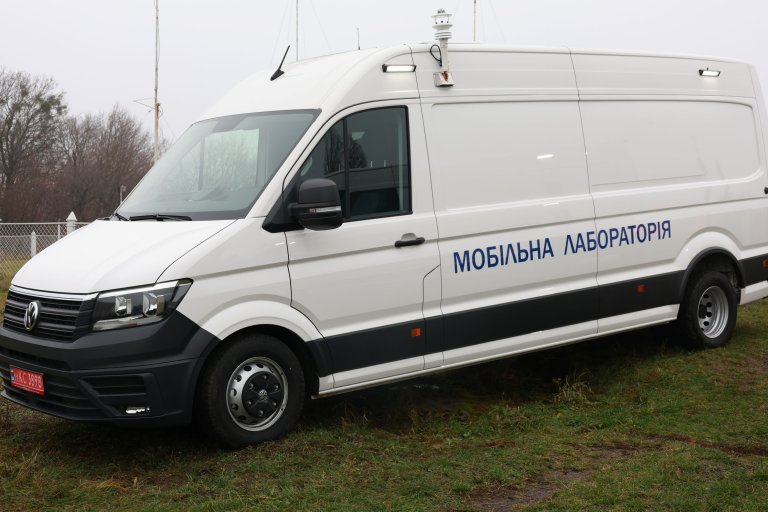 En hvit varebil med spesialantenne på taket.